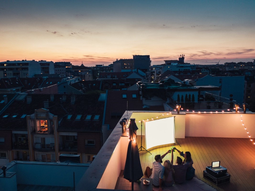 Friends at a rooftop movie night at sunset